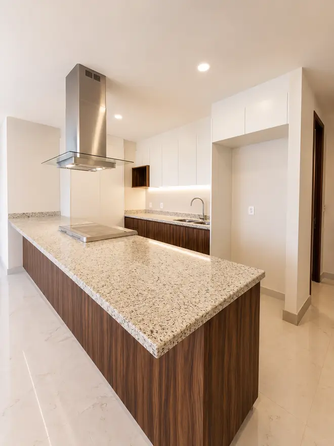 Isla de cocina en granito con gabinetes en nogal